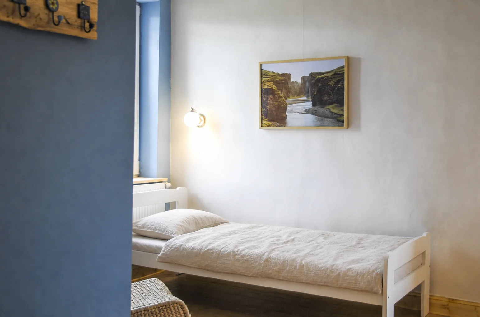 Einzelbett vor blau gestrichener Wand im selben Zimmer