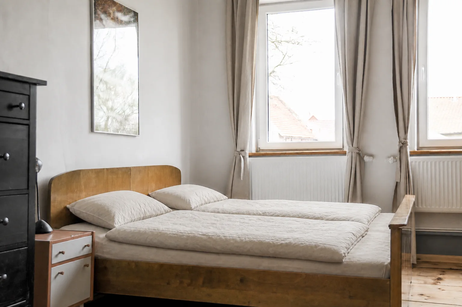 Schlafzimmer mit zwei Fenstern und Blick über die Dächer